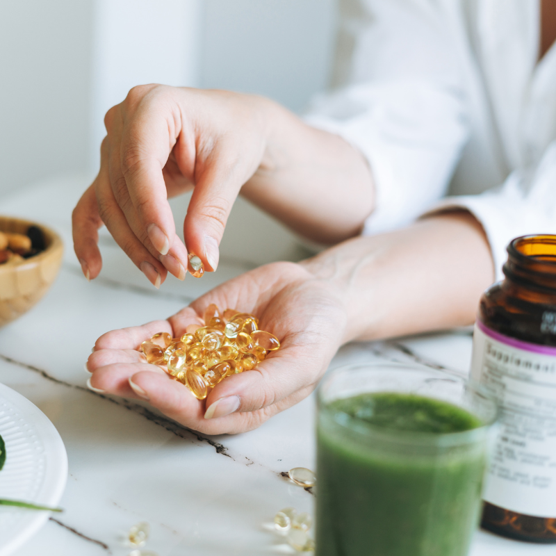 A woman holds different vitamin D options in her hand.