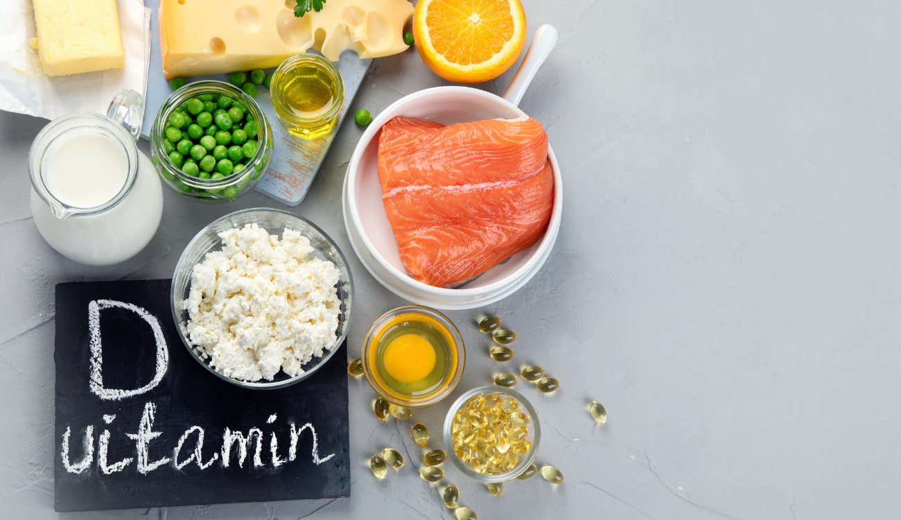 Several vitamin D-rich foods on a table, including fish, eggs, and milk.