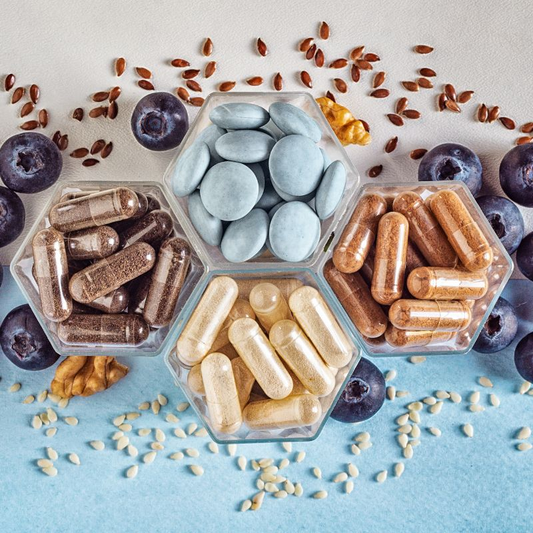 Image of several antioxidant pills and blackberries in background.