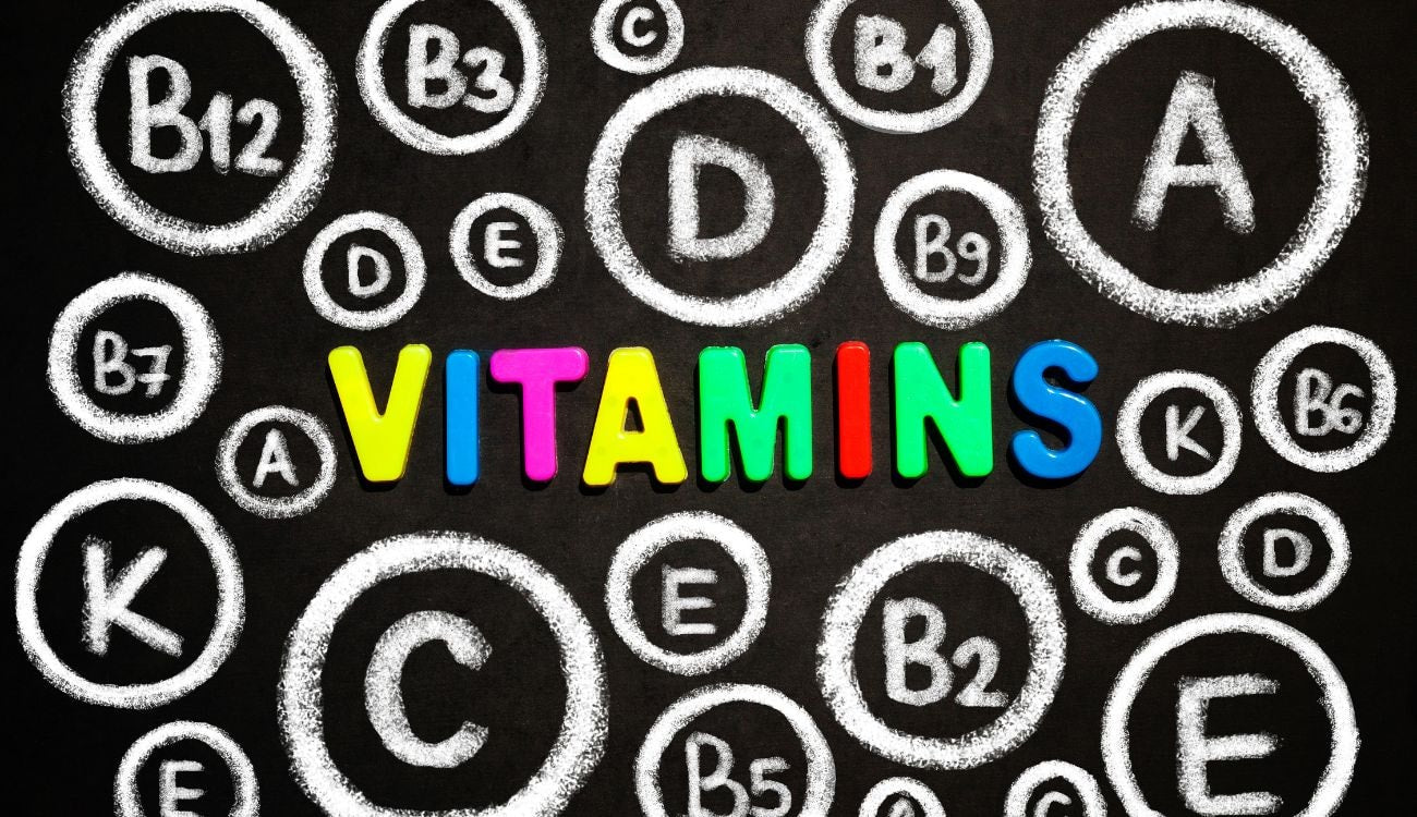 A blackboard showing various vitamin initials surrounding the word "vitamins" in the center.